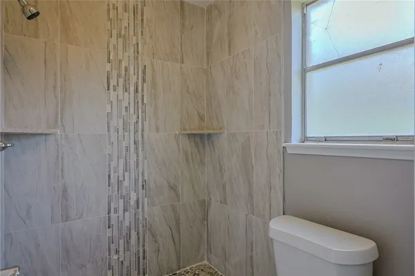 a white toilet sitting next to a shower curtain