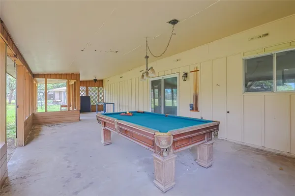 a room with pool table and windows