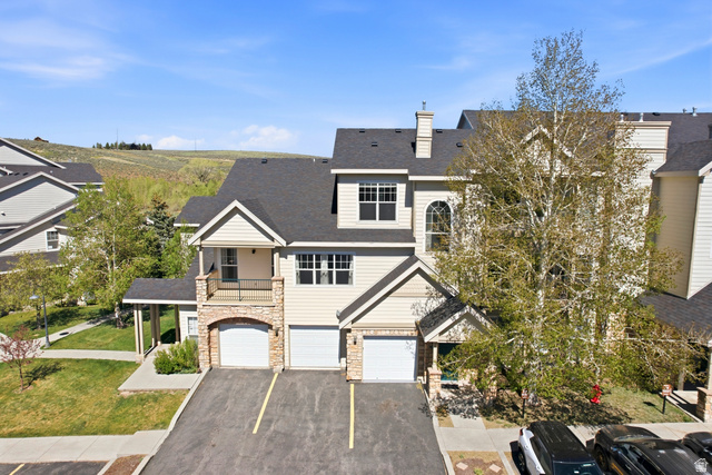 900 Bitner Road, Unit P20 Park City, UT 84098 - Photo 41 of 42 Multi-level townhome featuring a stone and siding exterior, multiple garage bays, and an upper-level balcony with a metal railing