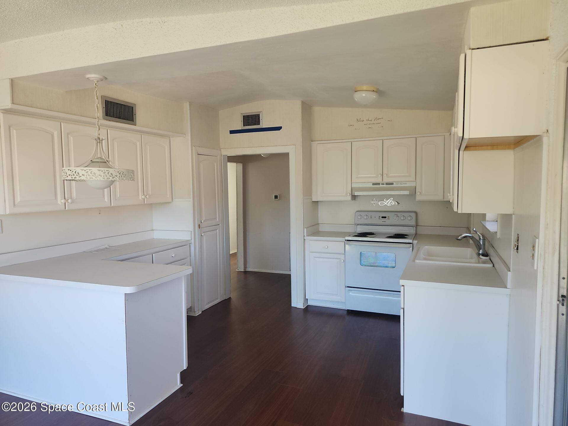 180 Church Road Merritt Island, FL 32953 - Photo 2 of 14 a kitchen with white cabinets and white appliances