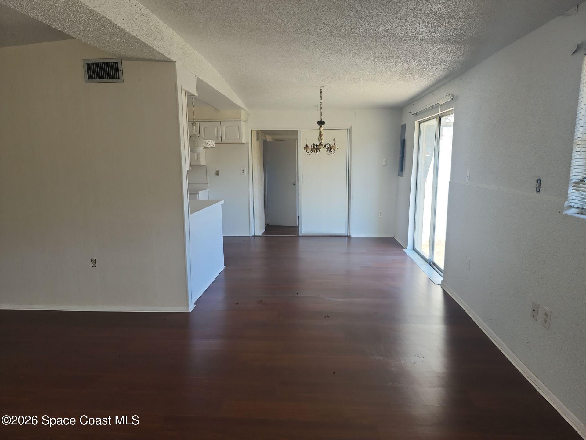 180 Church Road Merritt Island, FL 32953 - Photo 4 of 14 an empty room with wooden floor and windows