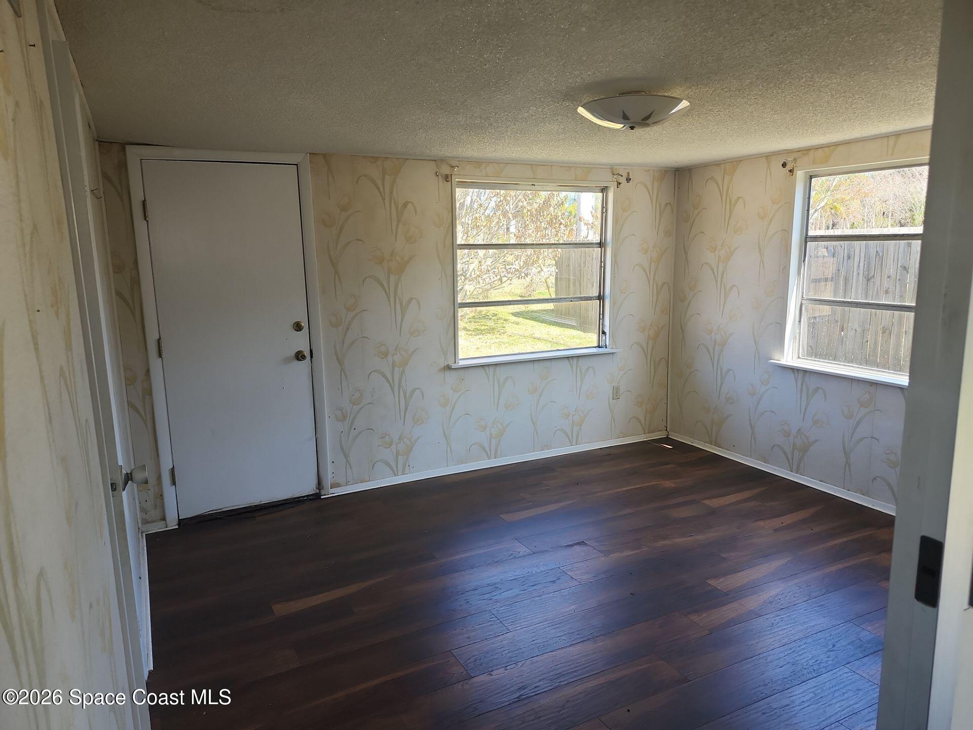 180 Church Road Merritt Island, FL 32953 - Photo 5 of 14 an empty room with wooden floor and windows