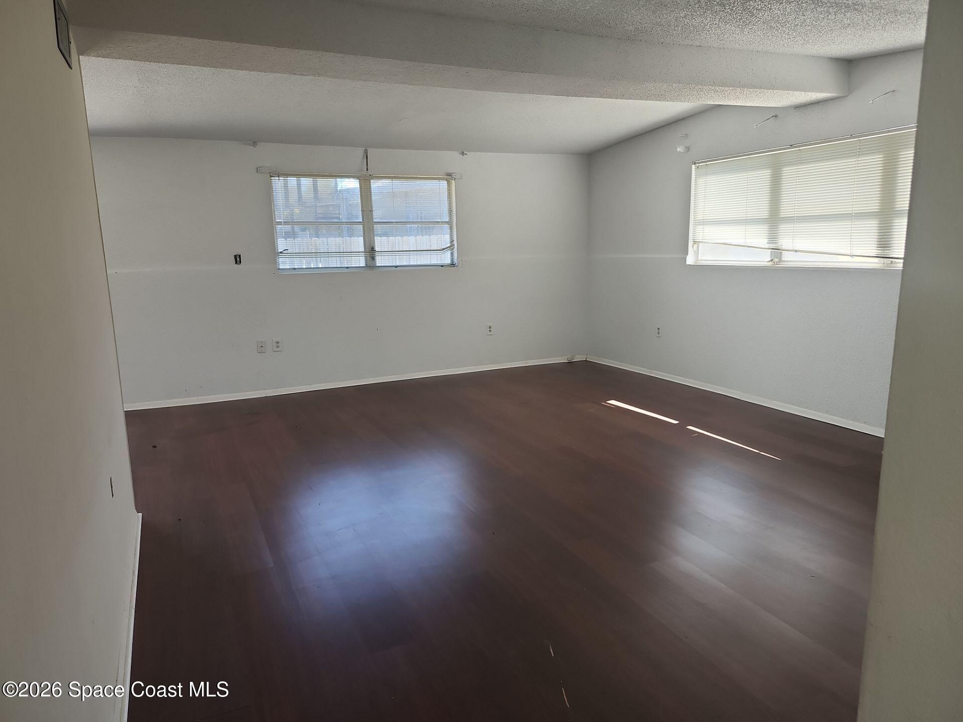 180 Church Road Merritt Island, FL 32953 - Photo 7 of 14 an empty room with wooden floor and windows
