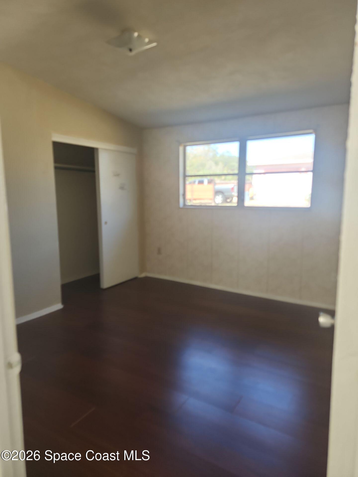 180 Church Road Merritt Island, FL 32953 - Photo 8 of 14 an empty room with wooden floor and windows