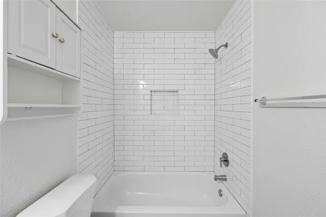 a bathroom with a bathtub and toilet