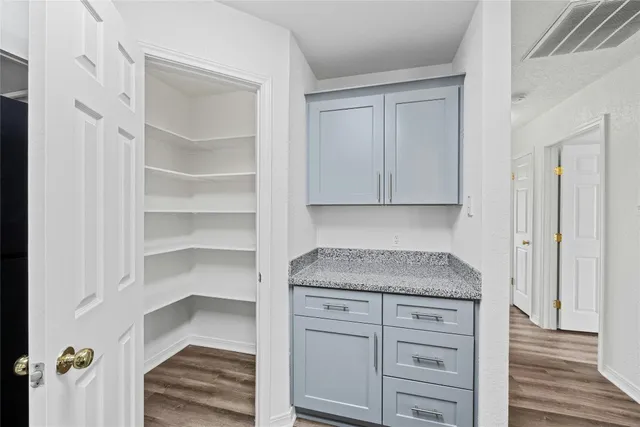 a kitchen with cabinets appliances and a wooden floor