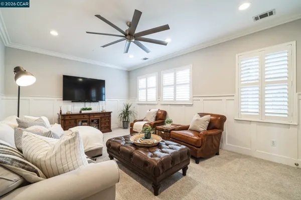 a living room with furniture a flat screen tv and a large window