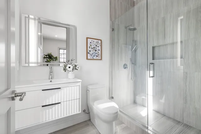 a bathroom with a sink a toilet and shower