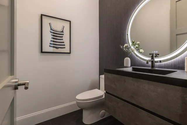 a bathroom with a toilet a sink and mirror