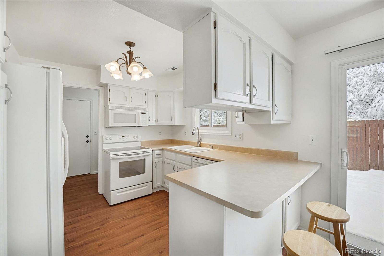 5257 Estes Circle Arvada, CO 80002 - Photo 8 of 22 a kitchen with granite countertop a stove a sink and cabinets