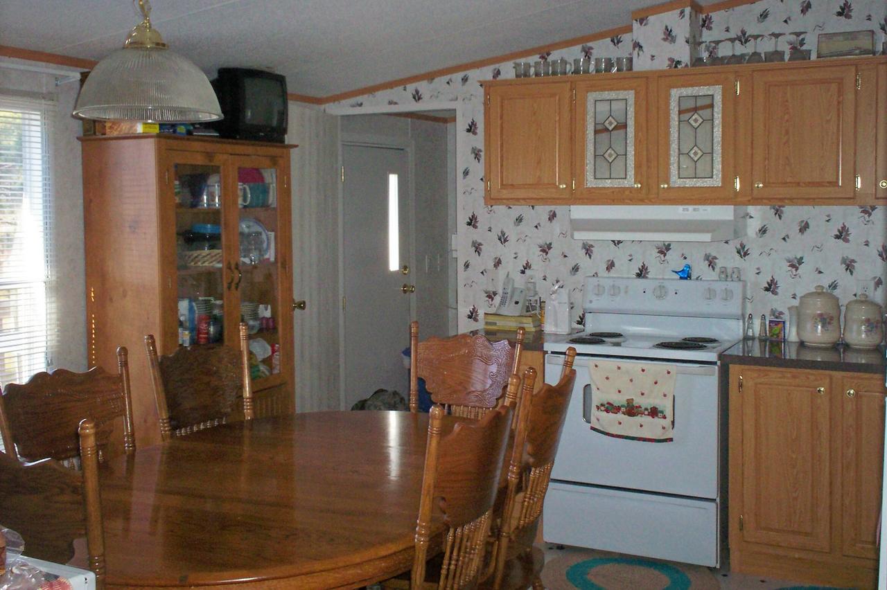 1775 Harmony School Road Hardy, VA 24101 - Photo 4 of 8 a kitchen with stainless steel appliances granite countertop a stove a refrigerator a dining table and chairs with wooden floor