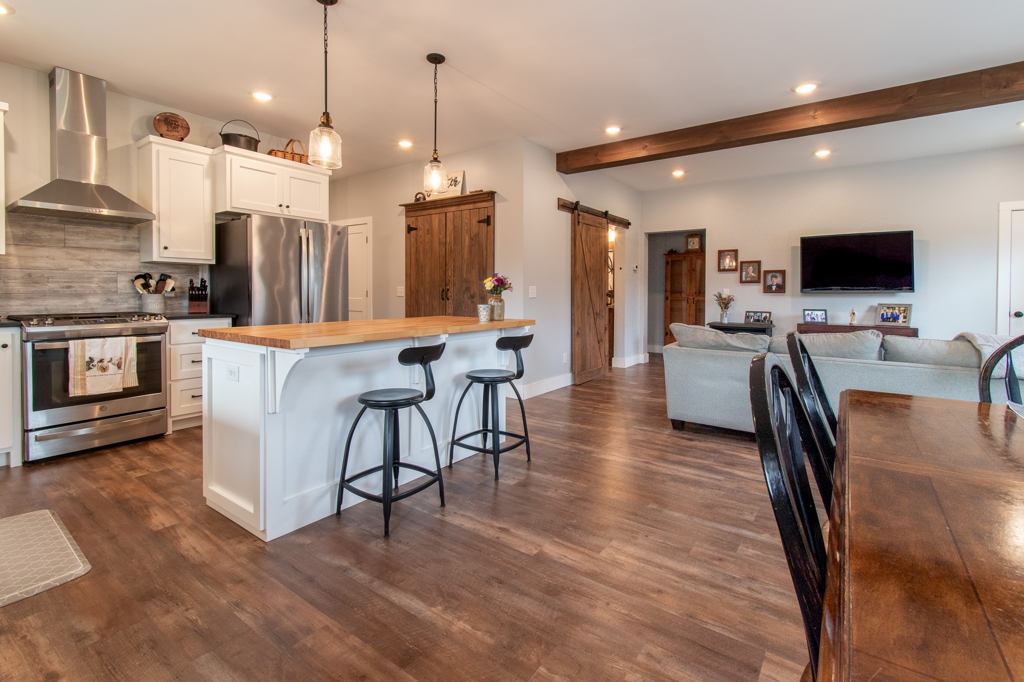 6490 Prospect Road Prospect, TN 38477 - Photo 19 of 52 a kitchen with stainless steel appliances kitchen island granite countertop a stove a refrigerator a kitchen island a dining table and chairs with wooden floor