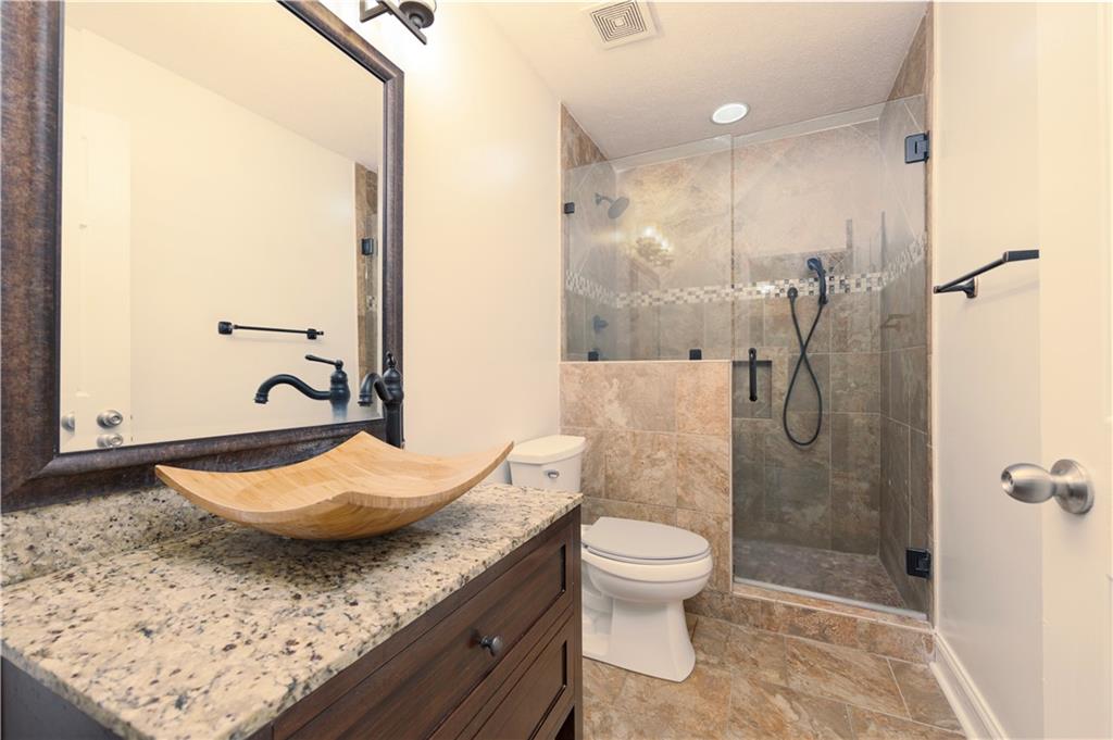 8 Ridgebrook Drive Phenix City, AL 36869 - Photo 18 of 21 Full bathroom with vanity, a shower stall, and stone finish flooring