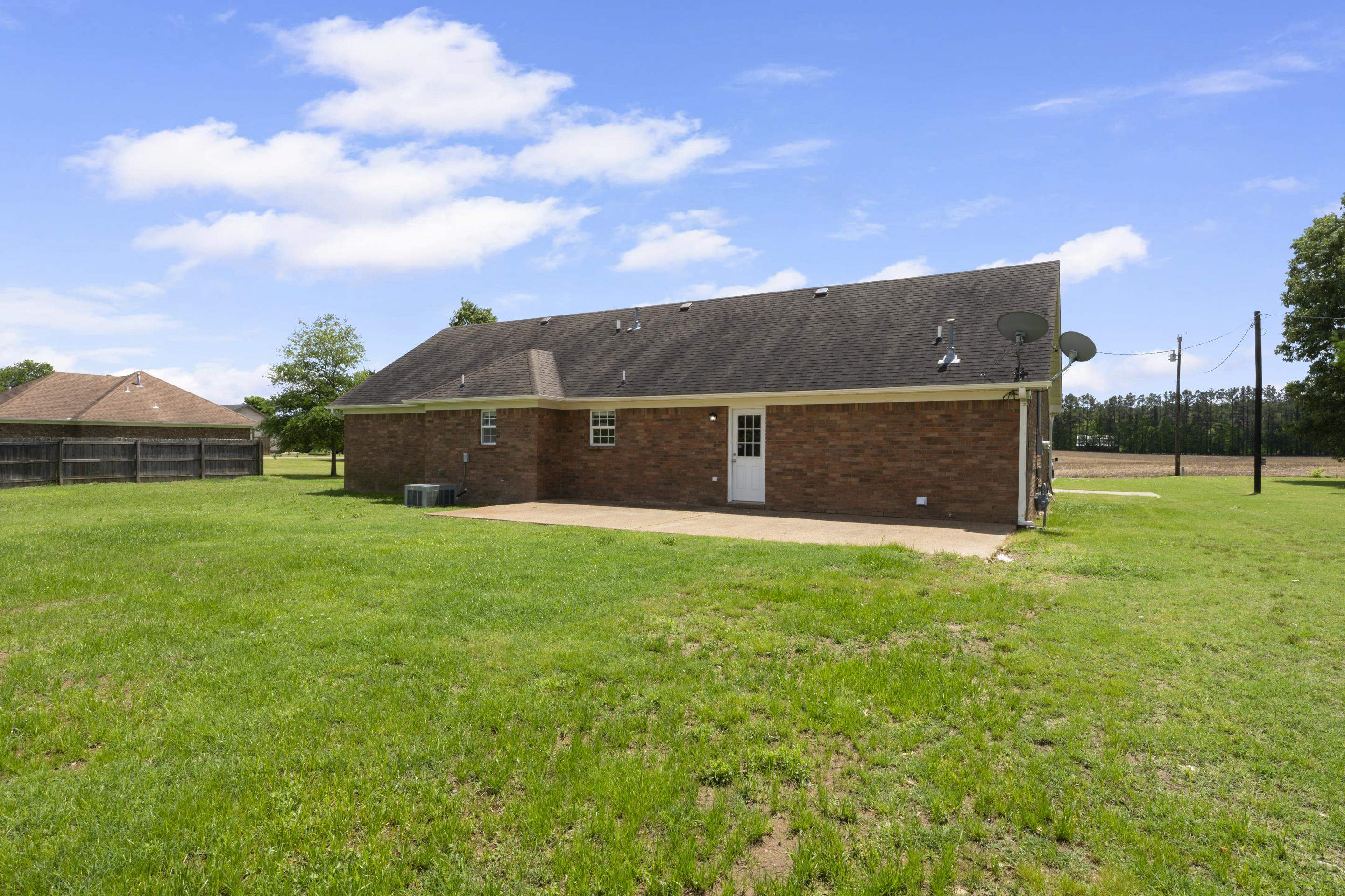 1038 Jamestown Road Burlison, TN 38015 - Photo 23 of 24 Back of house featuring a yard, a patio area, cooling unit, and brick siding