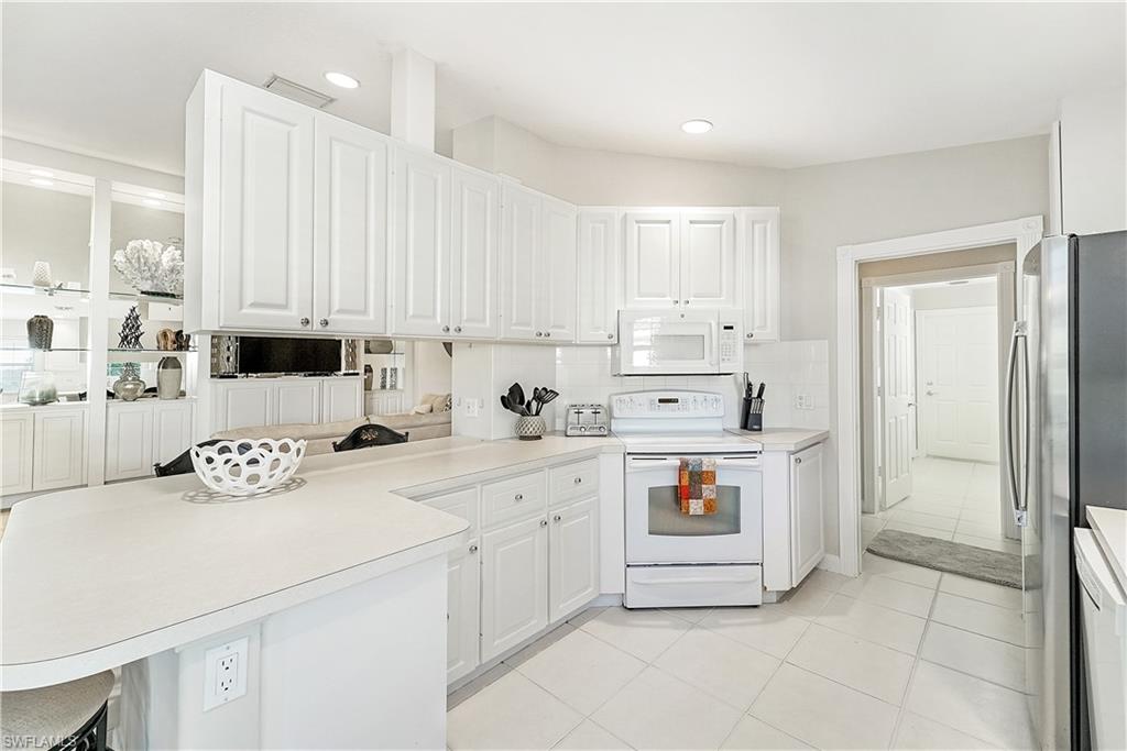 7767 Ionio Court Naples, FL 34114 - Photo 13 of 41 kitchen complete with plenty of storage and breakfast bar