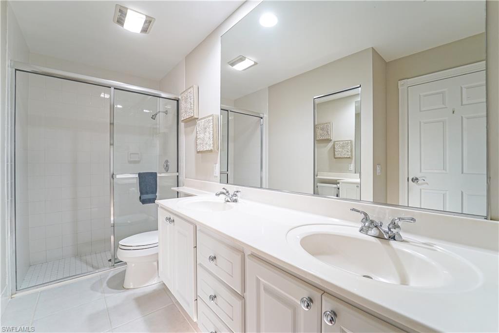 7767 Ionio Court Naples, FL 34114 - Photo 9 of 41 master bathroom complete with walk-in shower, dual vanity, and under cabinet lighting