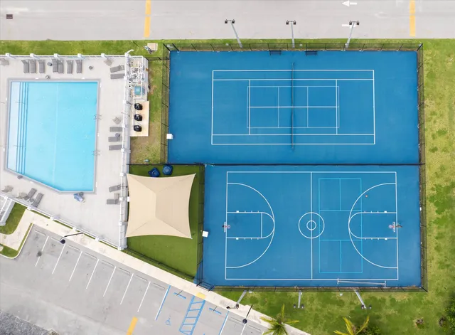 a view of a swimming pool with an outdoor seating and a lots of residential buildings in the background