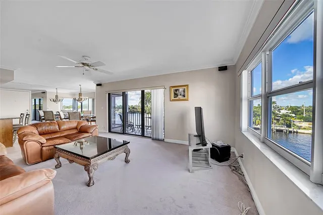 a living room with furniture a flat screen tv and a floor to ceiling window