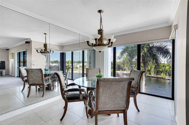 a open kitchen with stainless steel appliances granite countertop a table chairs and a chandelier