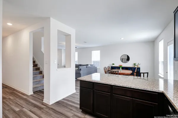 a kitchen with a sink dishwasher a refrigerator and wooden cabinets with wooden floor