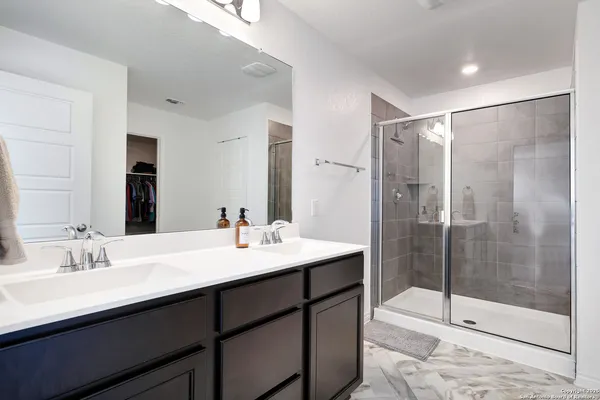 a bathroom with a shower sink and mirror