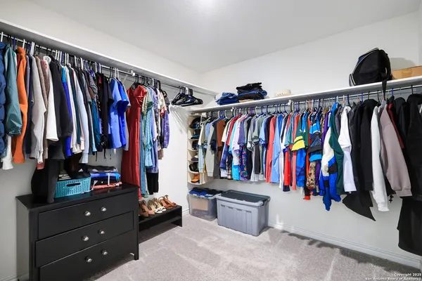 a view of walk in closet with clothes and shoes