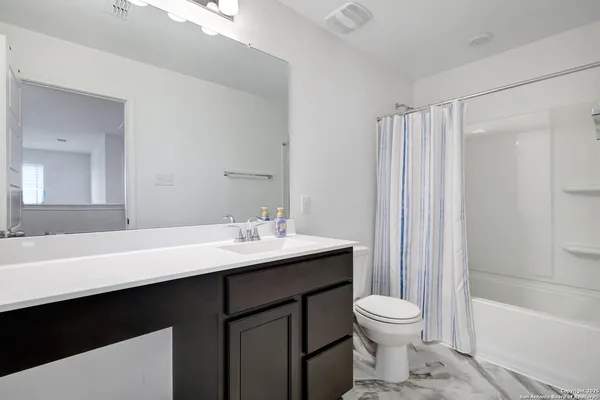 a bathroom with a sink toilet a mirror and shower