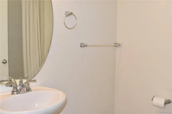 a bathroom with a sink a mirror and a shower curtain