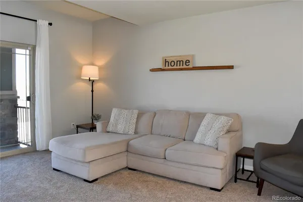 a living room with furniture and a lamp