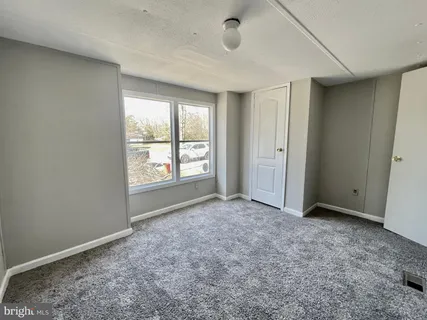 an empty room with windows and closet
