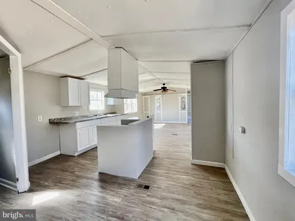 a kitchen with cabinets and wooden floor