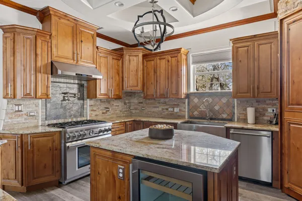 a kitchen with stainless steel appliances granite countertop a sink stove and cabinets