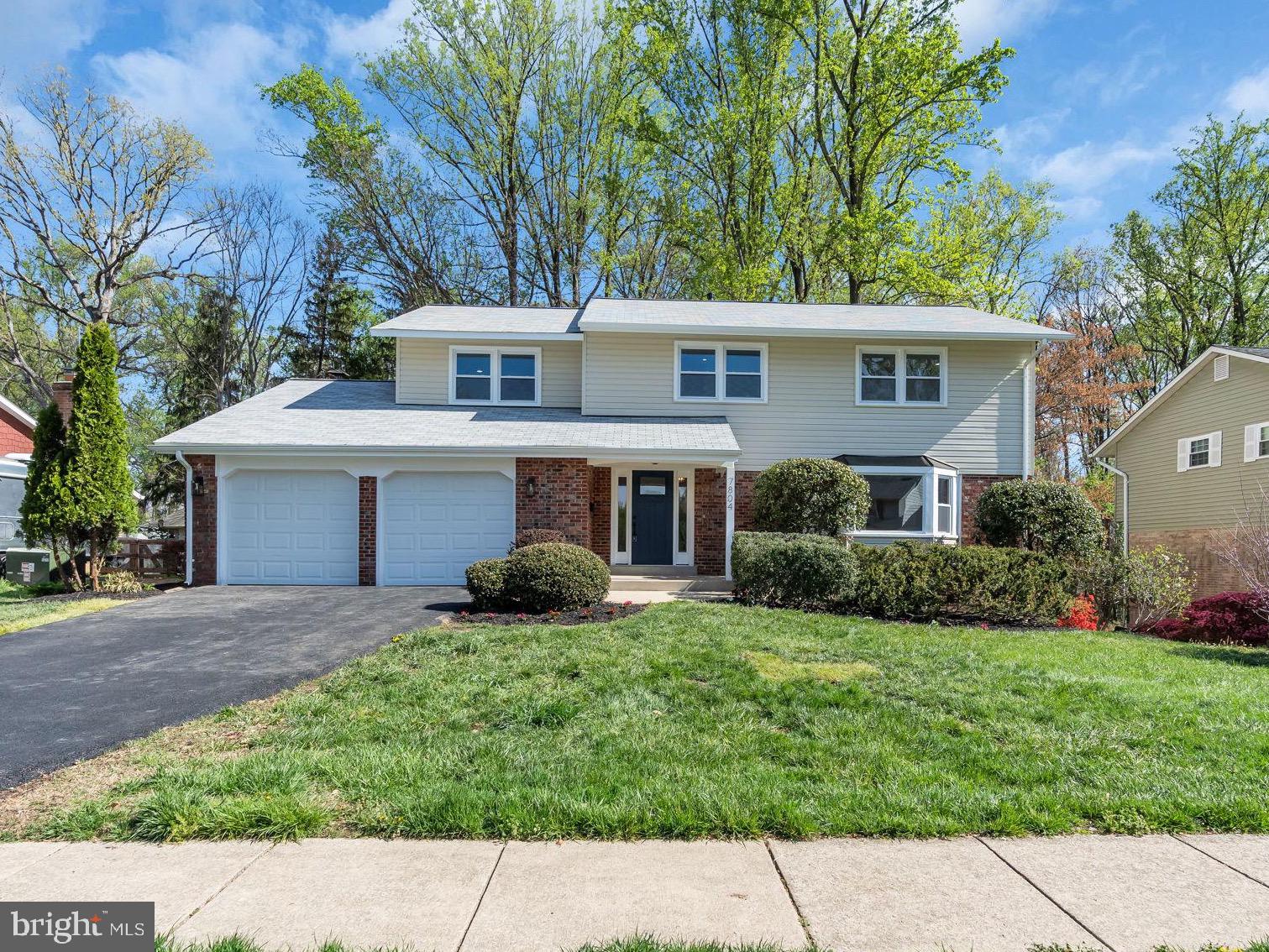 7804 Carrleigh Parkway Springfield, VA 22152 - Photo 1 of 61 a front view of a house with a garden and trees