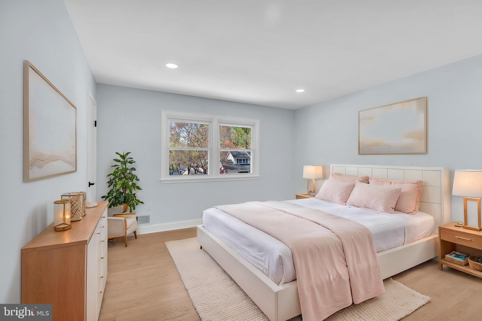 7804 Carrleigh Parkway Springfield, VA 22152 - Photo 31 of 61 a bedroom with a large bed potted plant and a window