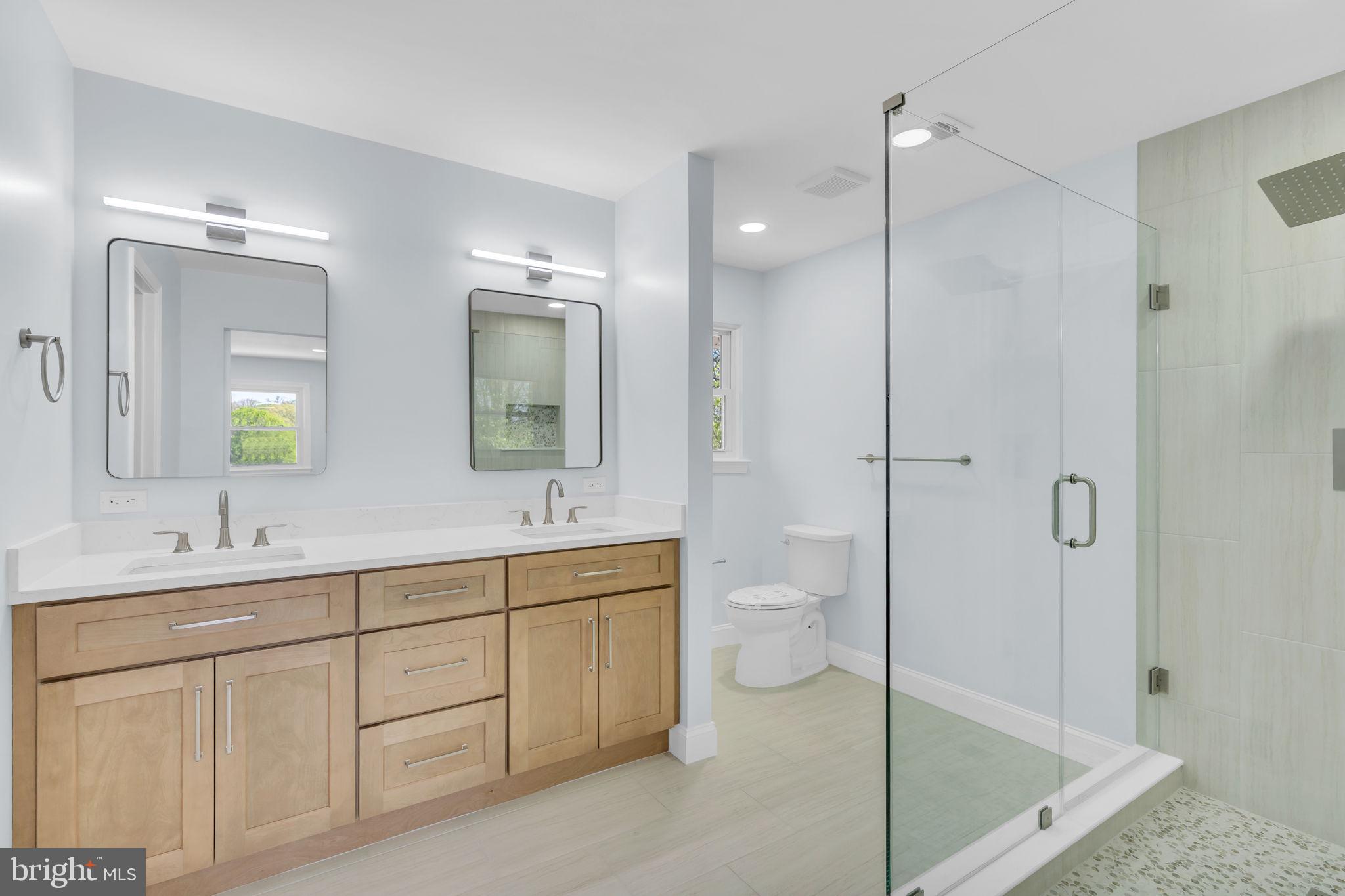 7804 Carrleigh Parkway Springfield, VA 22152 - Photo 33 of 61 a spacious bathroom with a shower sink mirror and toilet