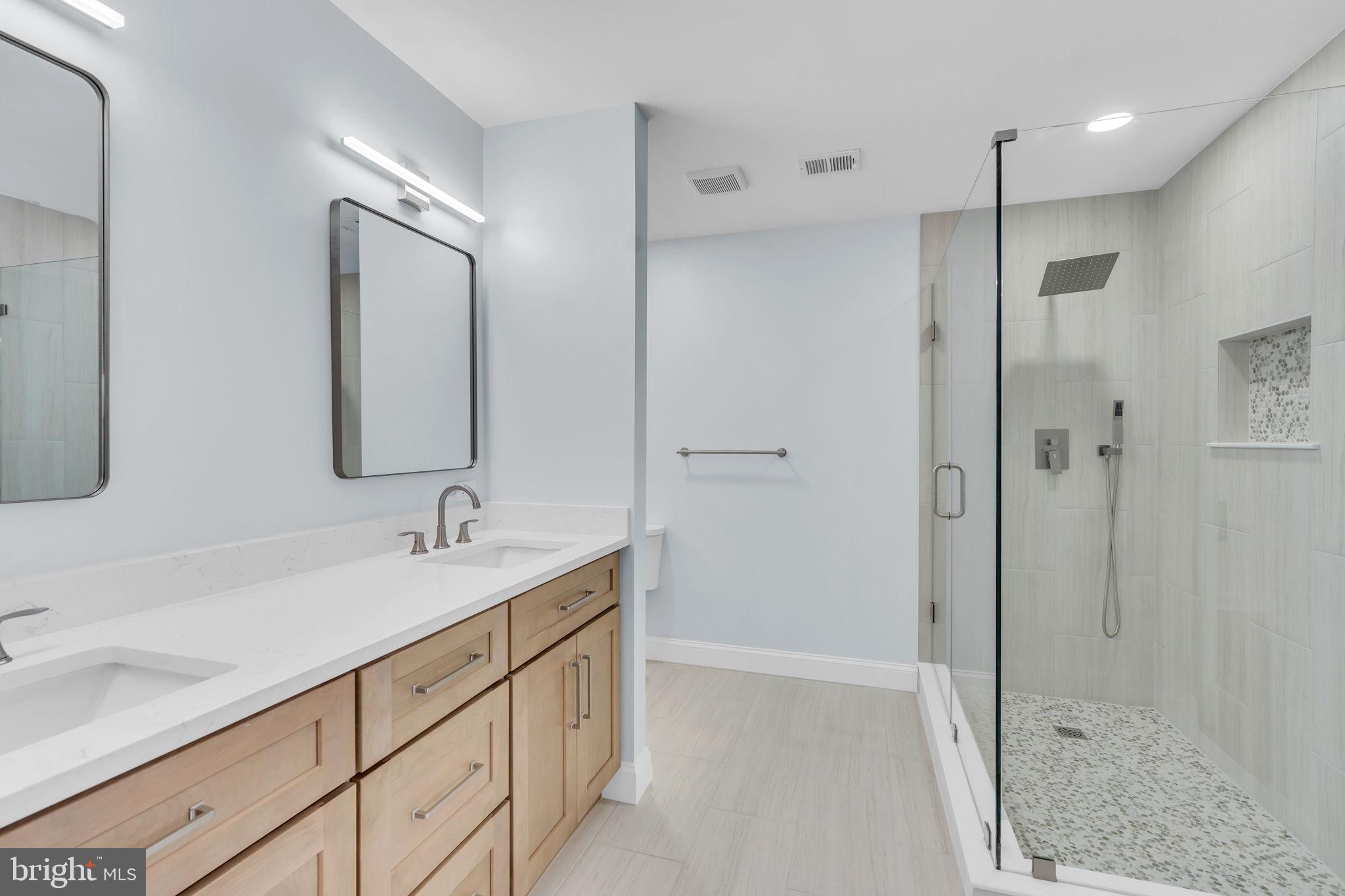7804 Carrleigh Parkway Springfield, VA 22152 - Photo 34 of 61 a bathroom with a shower sink and mirror