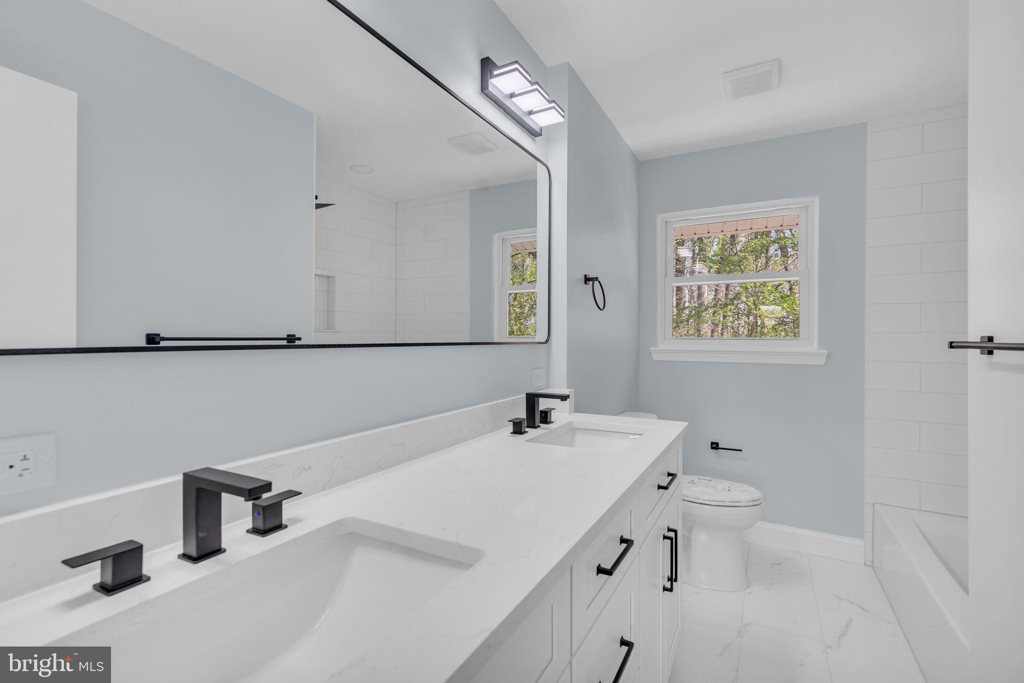 7804 Carrleigh Parkway Springfield, VA 22152 - Photo 45 of 61 a bathroom with a tub sink and mirror