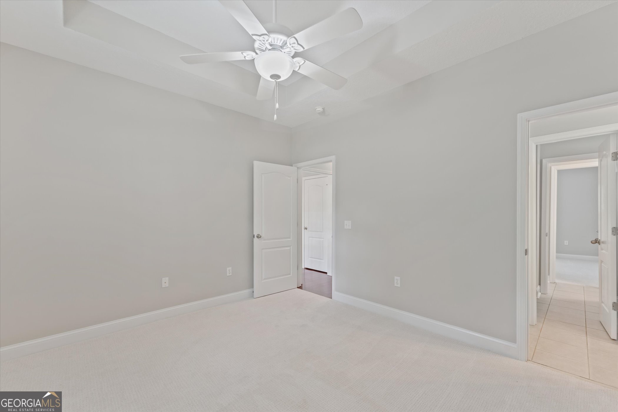 45 Veranda Trail Midway, GA 31320 - Photo 17 of 32 an empty room with a chandelier fan and windows