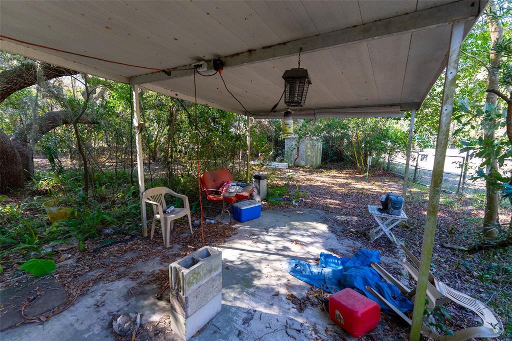 24971 Northeast 135th Street Salt Springs, FL 32134 - Photo 10 of 49 a view of a patio with table and chairs under an umbrella
