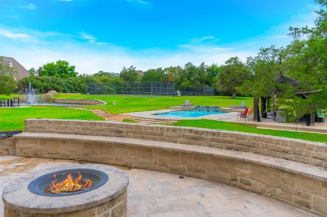 a view of a white house next to a yard and large trees