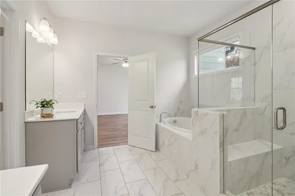a bathroom with a tub sink and mirror
