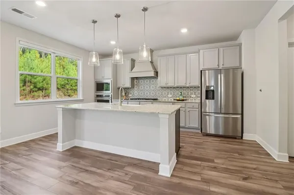 a kitchen with kitchen island a large counter top space stainless steel appliances and a window
