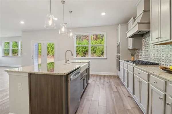 a kitchen with stainless steel appliances granite countertop a sink stove and cabinets