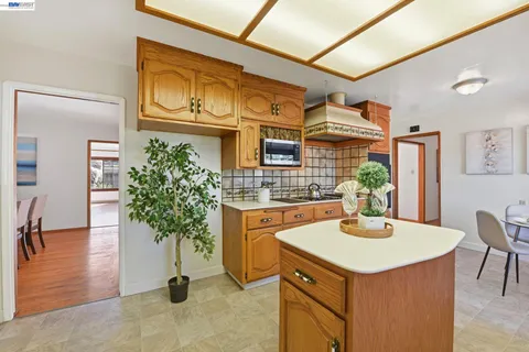 a dining room with furniture a chandelier and kitchen view
