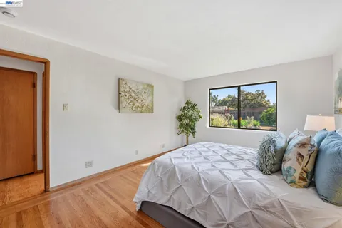 a bedroom with a bed and a potted plant