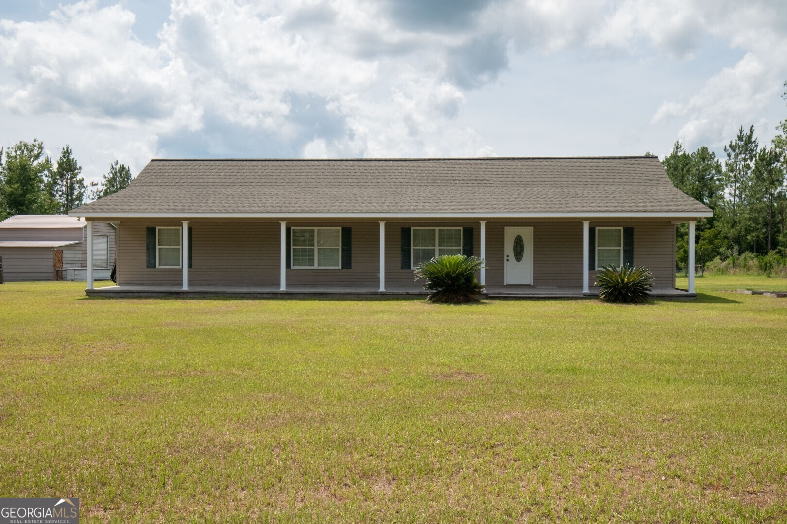 a front view of a house with a garden