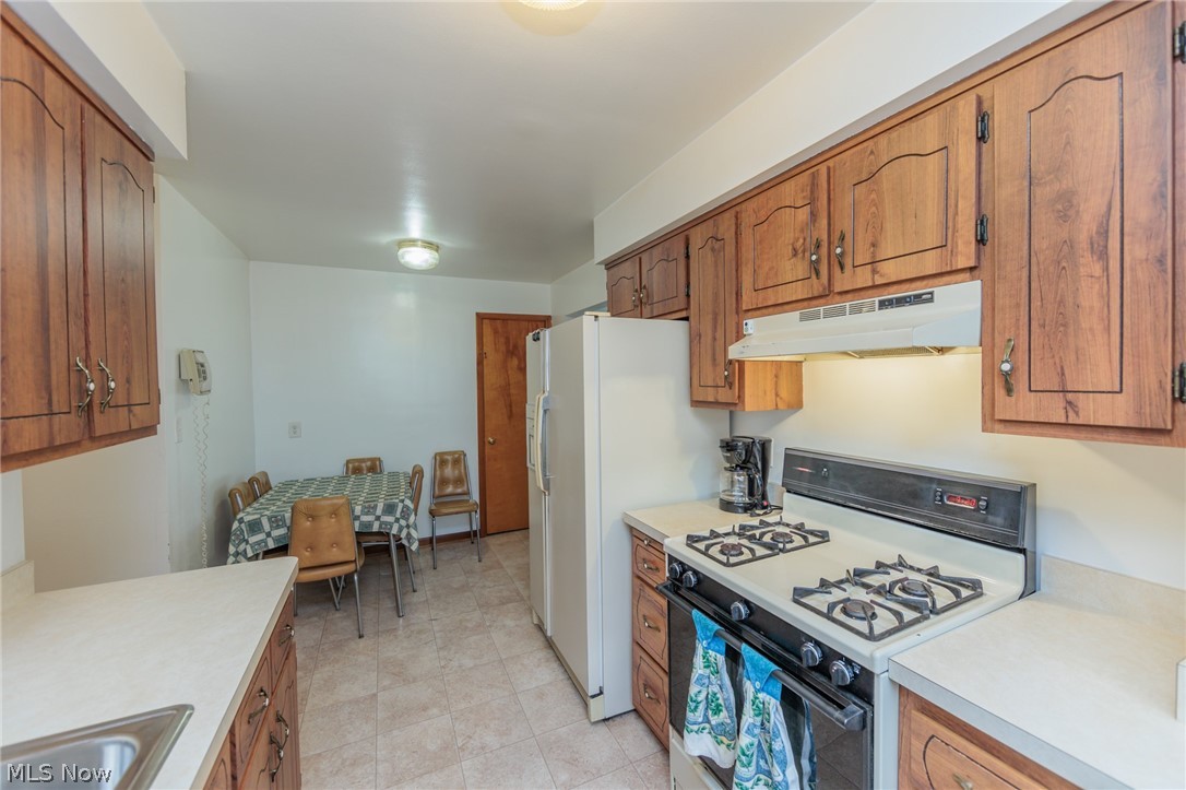 6147 Holburn Road Cleveland, OH 44129 - Photo 10 of 45 Kitchen with sink, gas range gas stove, and light tile patterned floors