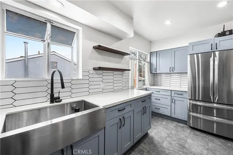 a kitchen with granite countertop a sink stainless steel appliances and cabinets