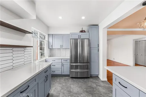 a kitchen with granite countertop a refrigerator and a sink