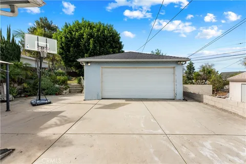 a view of a house with a yard and potted plants